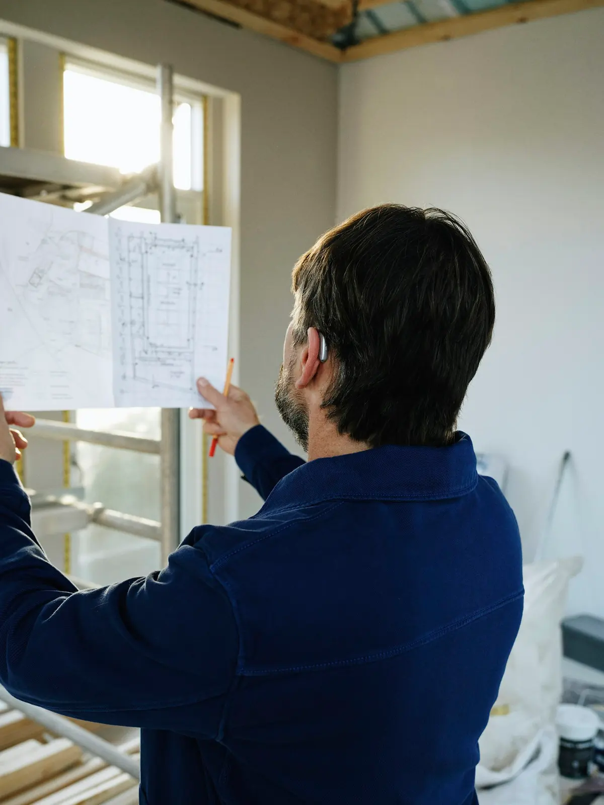 Contractor reviewing project blueprints on a job site