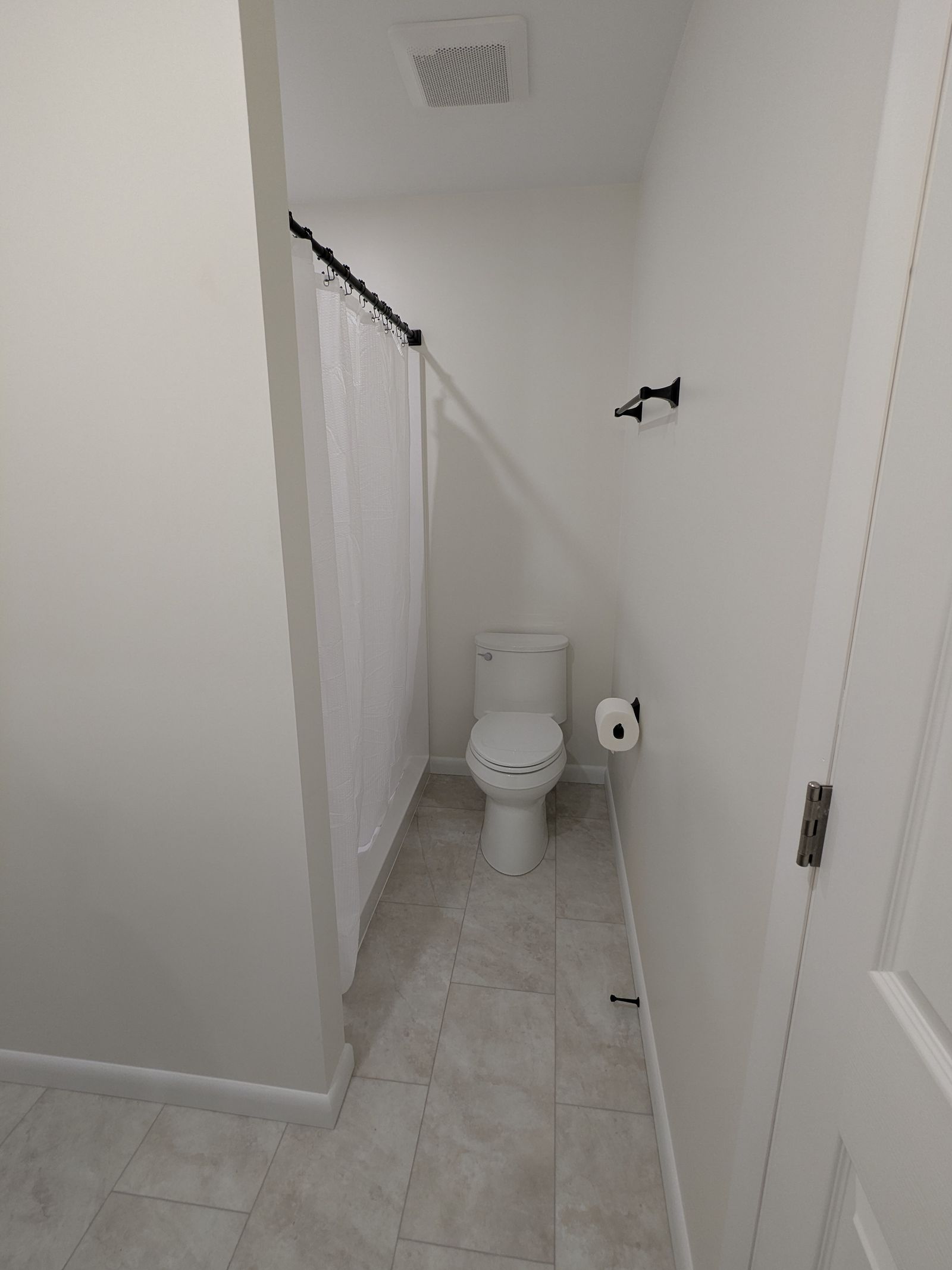 Remodeled bathroom with a new toilet and matte black hardware