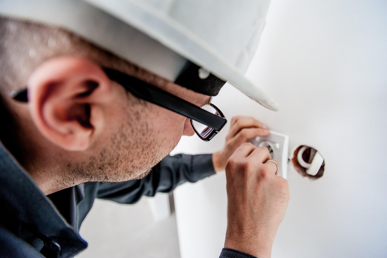 Electrician replacing a wall outlet